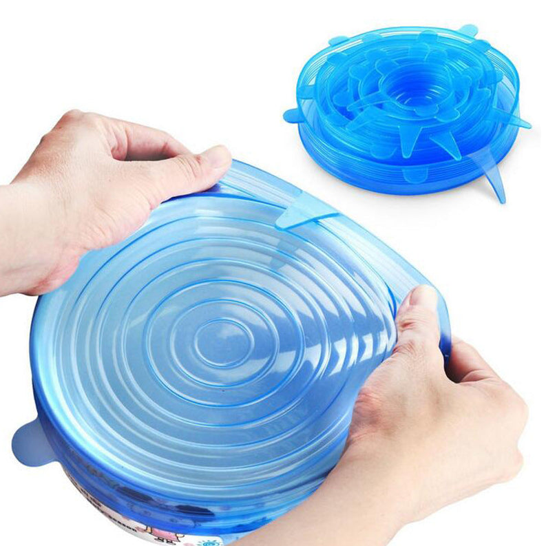 Blue silicone lid being stretched over a container by hands on a white background